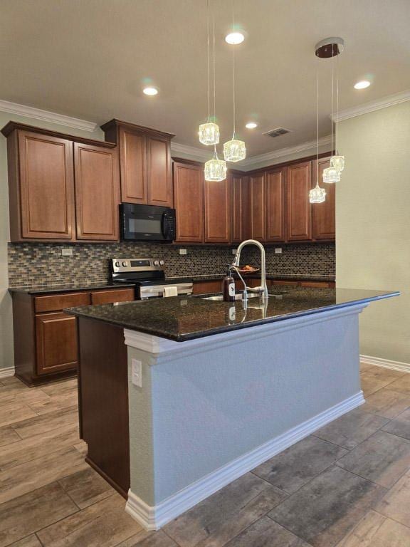kitchen featuring a sink, stainless steel range with electric cooktop, visible vents, a kitchen island with sink, and black microwave