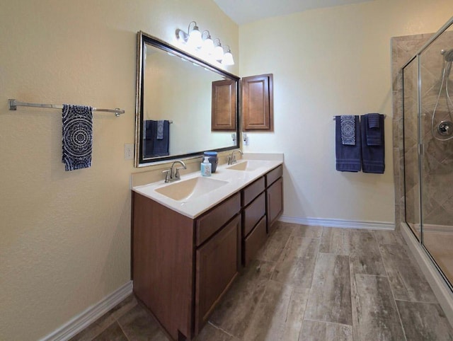 full bathroom featuring a shower stall, wood finished floors, and a sink