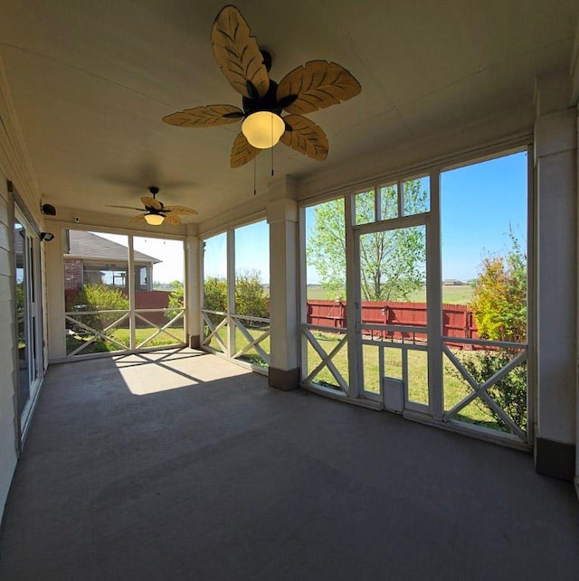 unfurnished sunroom featuring ceiling fan