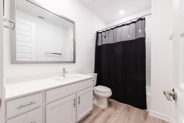 2233 Bravo Pass, Leander, TX 78641 - full bath featuring wood finished floors, vanity, toilet, and shower / tub combo with curtain