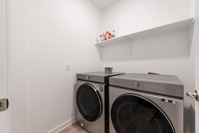2233 Bravo Pass, Leander, TX 78641 - laundry area with washing machine and dryer, baseboards, and light wood finished floors