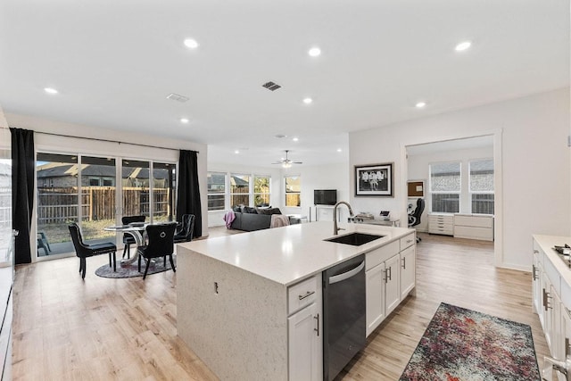 2233 Bravo Pass, Leander, TX 78641 - kitchen featuring dishwashing machine, a sink, light wood-type flooring, white cabinetry, and open floor plan