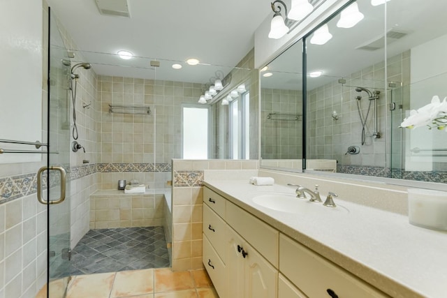 910 Old Stonehedge St, Austin, TX 78746 - full bathroom featuring a shower stall, vanity, tile patterned flooring, and tile walls
