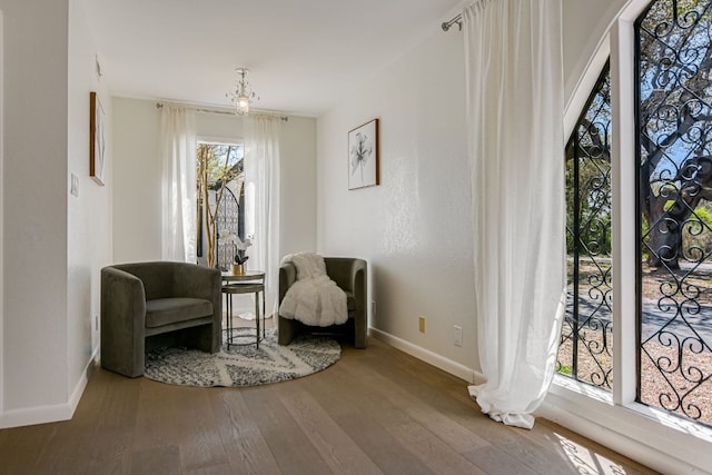 910 Old Stonehedge St, Austin, TX 78746 - living area featuring baseboards, wood-type flooring, and a chandelier