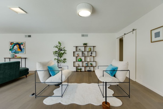 910 Old Stonehedge St, Austin, TX 78746 - living area featuring wood finished floors, a barn door, and baseboards