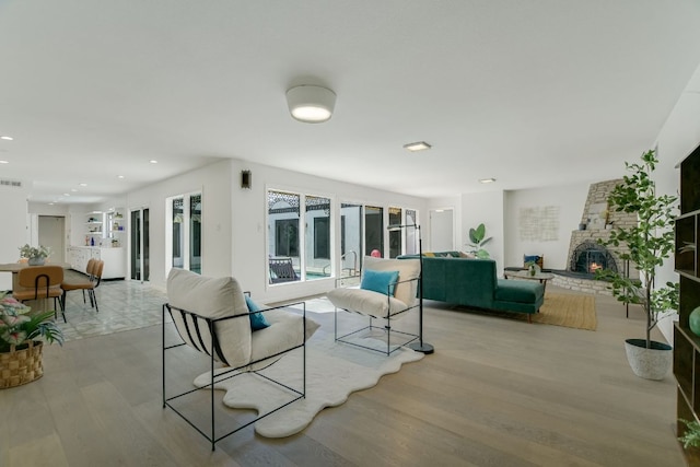 910 Old Stonehedge St, Austin, TX 78746 - living area featuring light wood-style flooring, a stone fireplace, and recessed lighting