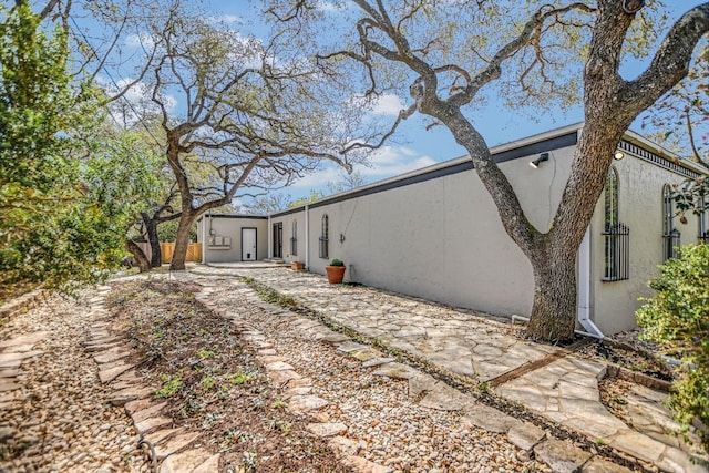 910 Old Stonehedge St, Austin, TX 78746 - rear view of house featuring stucco siding and a patio