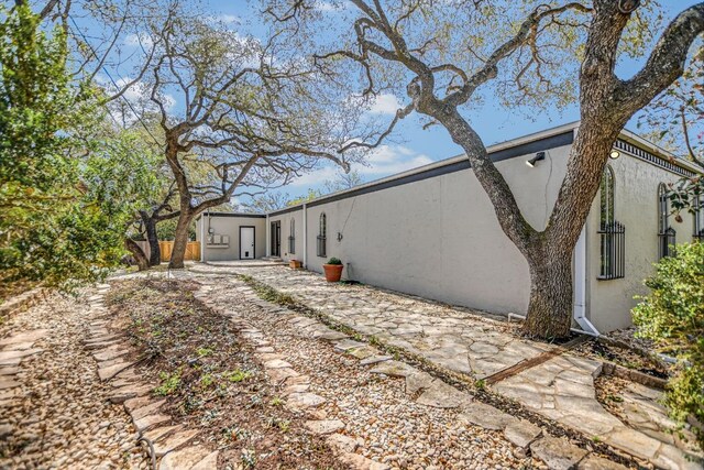 910 Old Stonehedge St, Austin, TX 78746 - rear view of property featuring stucco siding and a patio