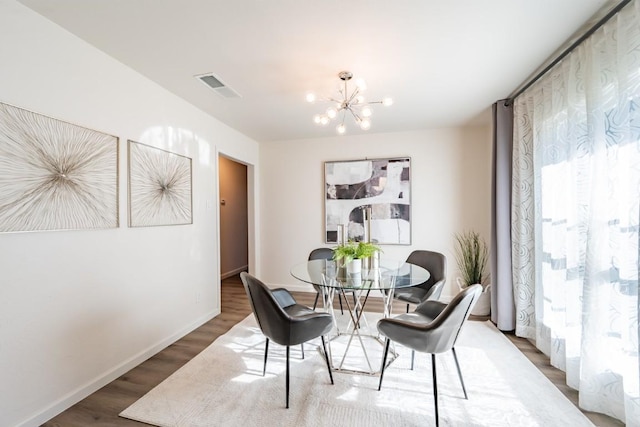 12303 Bainbridge Ln, Austin, TX 78750 - dining room featuring a chandelier, wood finished floors, baseboards, and plenty of natural light