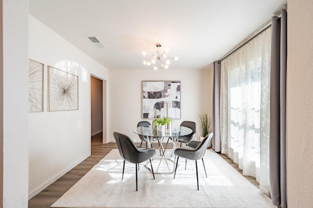 12303 Bainbridge Ln, Austin, TX 78750 - dining area with wood finished floors, a chandelier, and baseboards
