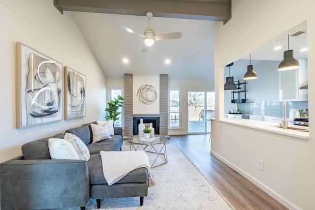 12303 Bainbridge Ln, Austin, TX 78750 - living area with wood finished floors, a ceiling fan, baseboards, a fireplace, and beam ceiling