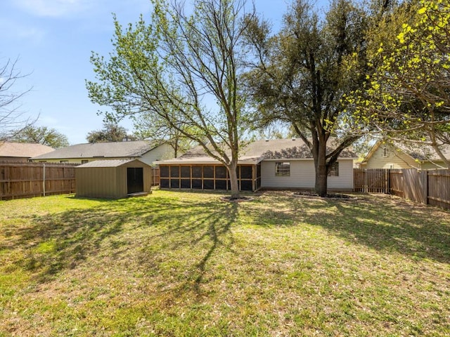 view of yard with an outdoor structure, a fenced backyard, a sunroom, and a storage unit