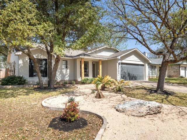 ranch-style house with driveway, brick siding, and a garage