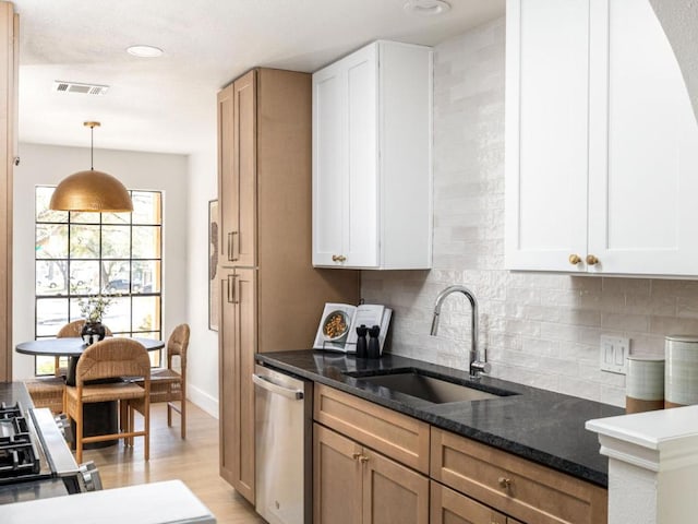 kitchen featuring backsplash, a sink, dishwasher, dark stone countertops, and visible vents