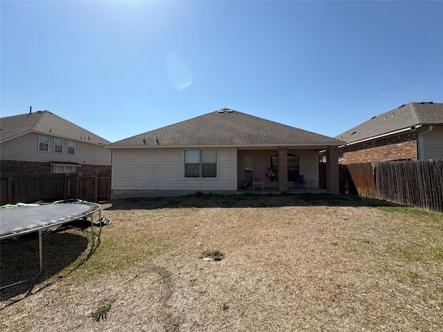 2316 Dovetail St, Pflugerville, TX 78660 - rear view of house with a trampoline, a fenced backyard, and a patio
