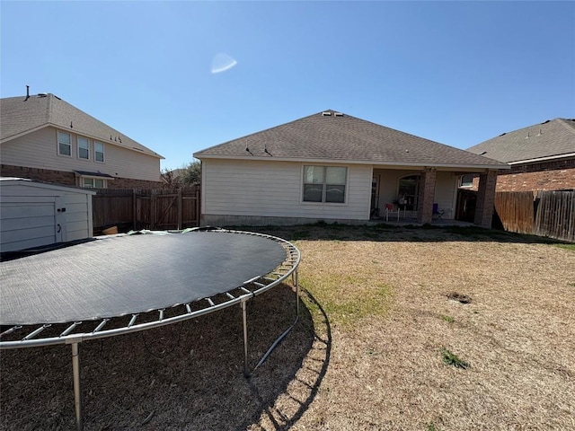 2316 Dovetail St, Pflugerville, TX 78660 - back of property featuring a trampoline, a fenced backyard, and a shed