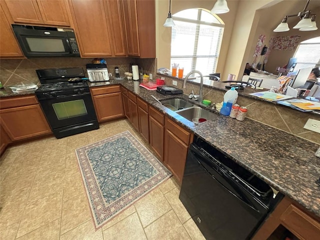 2316 Dovetail St, Pflugerville, TX 78660 - kitchen with black appliances, brown cabinetry, tasteful backsplash, and pendant lighting