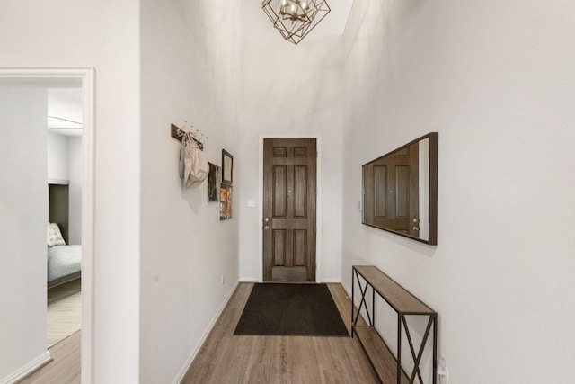 277 Biscayne Bay Bnd, Kyle, TX 78640 - hall featuring wood finished floors, a high ceiling, and a chandelier
