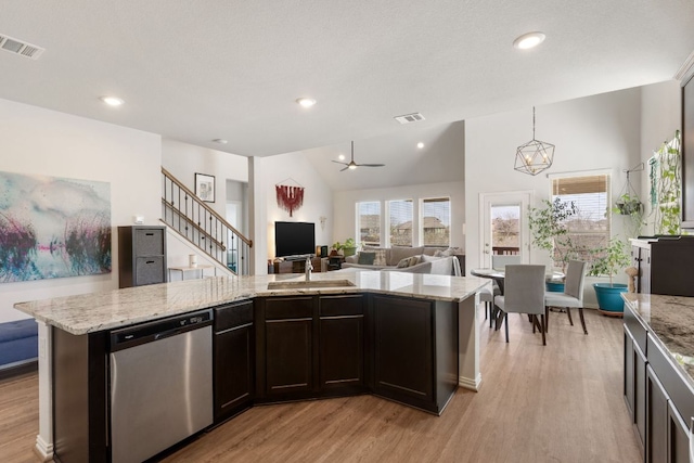277 Biscayne Bay Bnd, Kyle, TX 78640 - kitchen with stainless steel dishwasher, light wood finished floors, open floor plan, light stone countertops, and recessed lighting