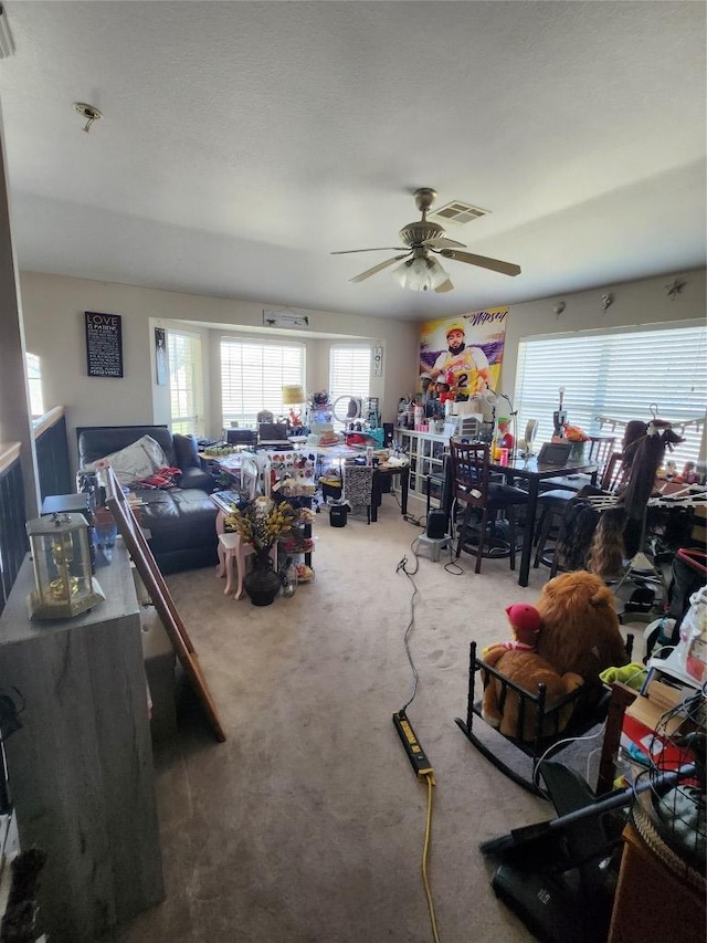 carpeted living area featuring a ceiling fan and visible vents