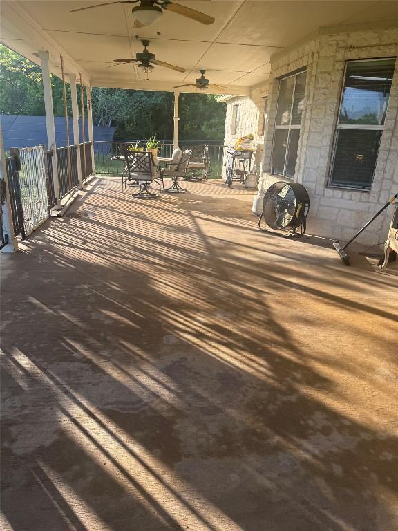 wooden terrace with covered porch, ceiling fan, and outdoor dining space
