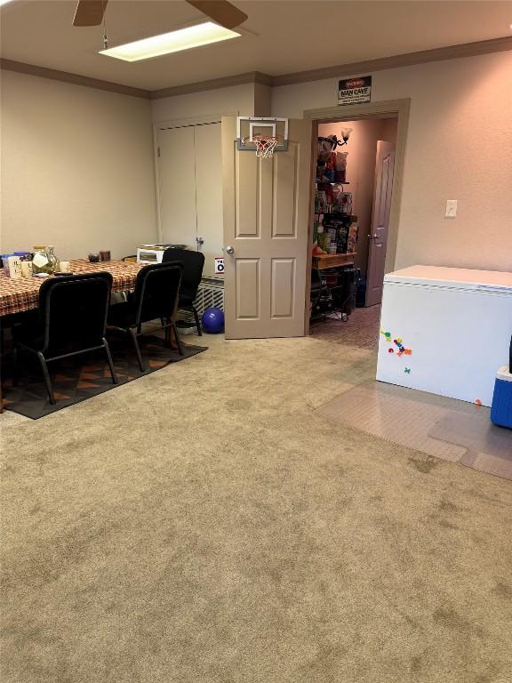 home office with ceiling fan, ornamental molding, and carpet