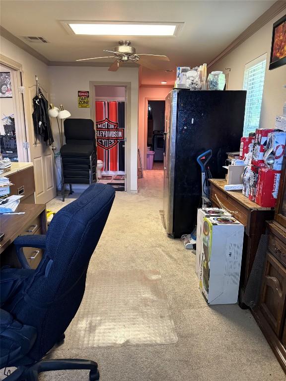 home office with ornamental molding, a ceiling fan, visible vents, and light colored carpet