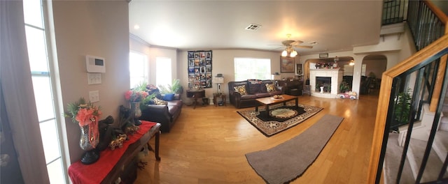 1149 State Highway 21 W Unit A, Cedar Creek, TX 78612 - living area featuring crown molding, a ceiling fan, a fireplace with raised hearth, and wood finished floors