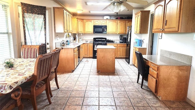 1149 State Highway 21 W Unit A, Cedar Creek, TX 78612 - kitchen with black appliances, a kitchen island, a ceiling fan, a sink, and ornamental molding