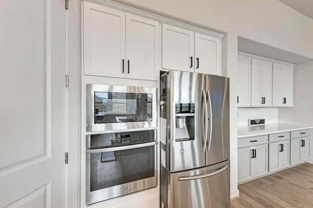2112 High Victory Rd, Leander, TX 78641 - kitchen with appliances with stainless steel finishes, white cabinets, light wood finished floors, and light countertops