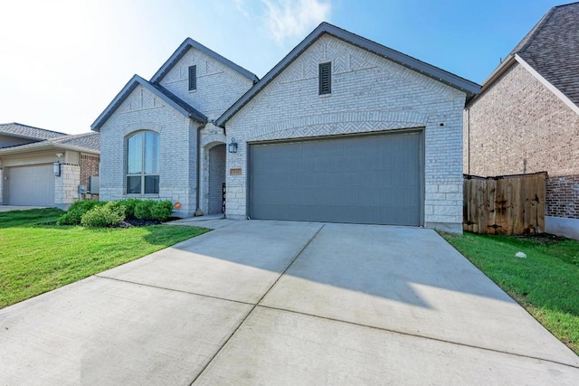 2112 High Victory Rd, Leander, TX 78641 - french country home with driveway, an attached garage, brick siding, and a front yard