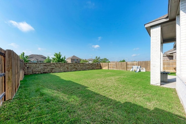 view of yard featuring central AC and a fenced backyard
