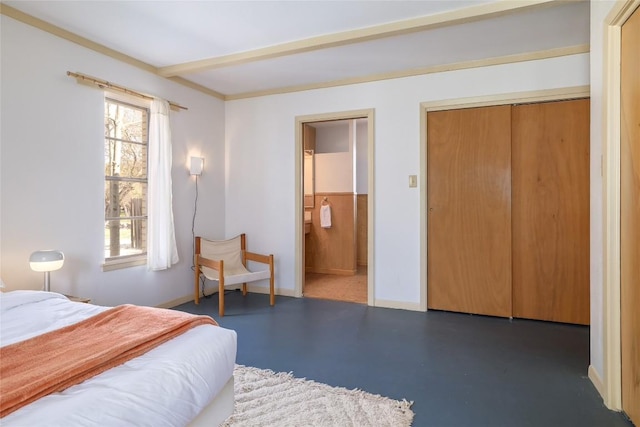 305 Reimer Ave, San Marcos, TX 78666 - bedroom featuring baseboards, multiple windows, finished concrete floors, ensuite bath, and beam ceiling