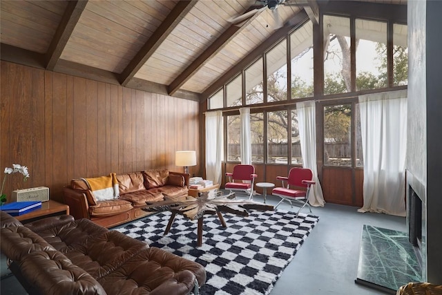 305 Reimer Ave, San Marcos, TX 78666 - living room with finished concrete floors, wooden walls, beamed ceiling, a fireplace, and high vaulted ceiling