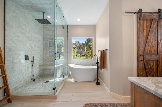 bathroom with a freestanding bath, vanity, tile patterned flooring, and a shower stall