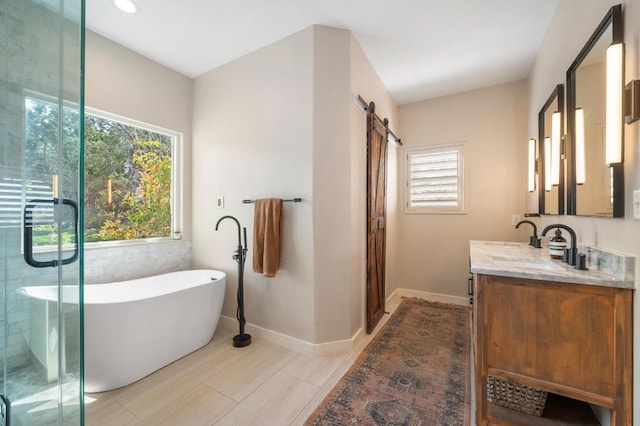 full bathroom featuring a soaking tub, plenty of natural light, baseboards, and vanity