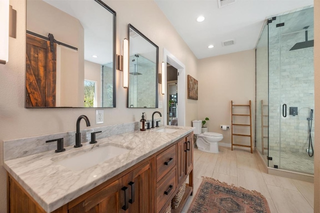 full bath with a sink, double vanity, a shower stall, and visible vents