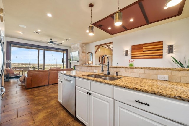 kitchen featuring a ceiling fan, stainless steel dishwasher, decorative light fixtures, a sink, and white cabinetry