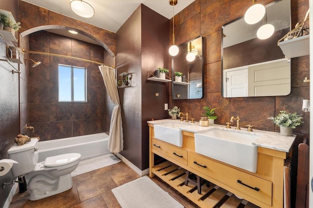 bathroom with double vanity, toilet, shower / tub combo with curtain, and a sink