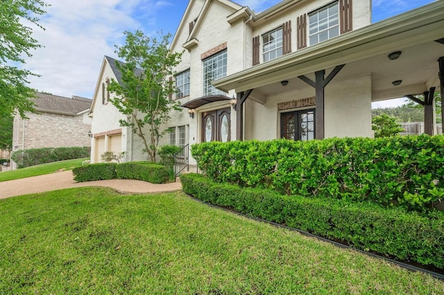 12029 Portobella Dr, Austin, TX 78732 - view of front facade with stucco siding, a front lawn, and a garage