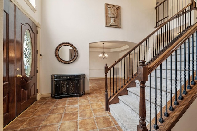 12029 Portobella Dr, Austin, TX 78732 - entryway with baseboards, a chandelier, arched walkways, stairs, and a towering ceiling
