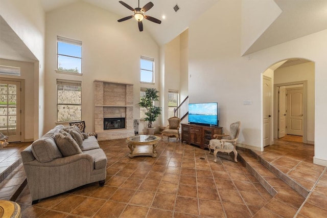 12029 Portobella Dr, Austin, TX 78732 - living room with a ceiling fan, high vaulted ceiling, arched walkways, a glass covered fireplace, and baseboards