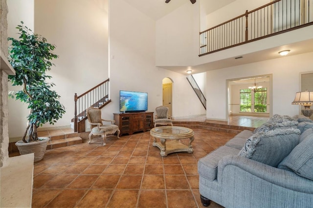 12029 Portobella Dr, Austin, TX 78732 - living room featuring stairs, a towering ceiling, arched walkways, a chandelier, and a ceiling fan