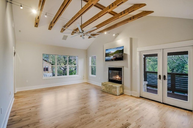 1701 Ravey St, Austin, TX 78704 - unfurnished living room with track lighting, plenty of natural light, wood finished floors, french doors, and high vaulted ceiling