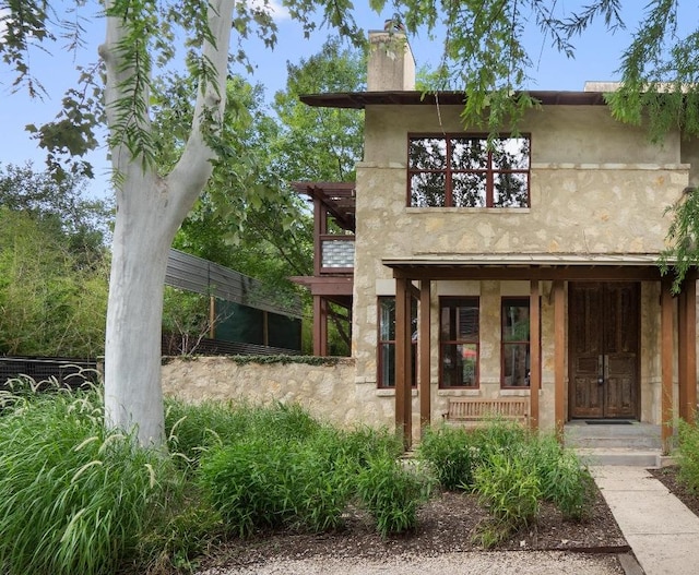 1701 Ravey St, Austin, TX 78704 - view of front of house with a chimney, stucco siding, and a porch