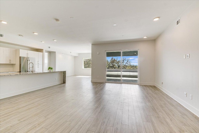 1715 Enfield Rd Unit 302, Austin, TX 78703 - unfurnished living room with light wood-type flooring and recessed lighting