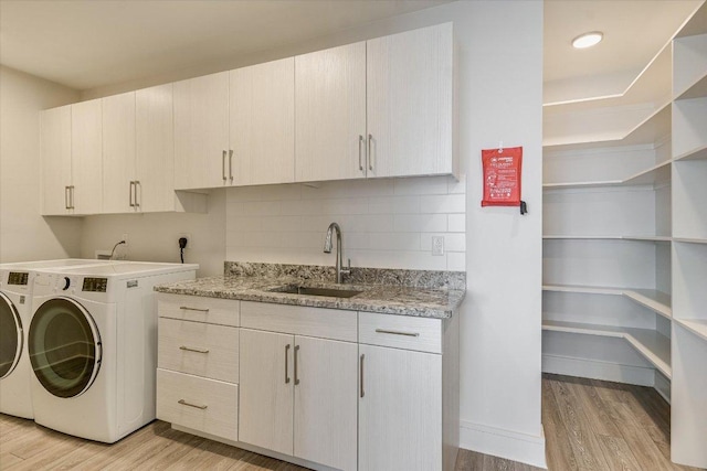 1715 Enfield Rd Unit 302, Austin, TX 78703 - laundry room featuring washer and clothes dryer, cabinet space, and light wood-style floors