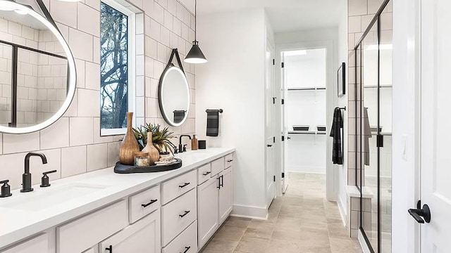 309 Golden Sage Ave, Georgetown, TX 78633 - bathroom with double vanity, a spacious closet, a shower stall, and backsplash