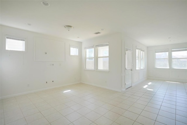 spare room featuring light tile patterned floors, baseboards, and visible vents