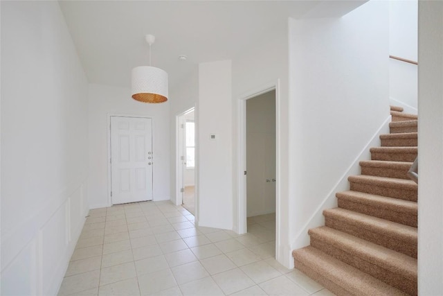 entryway featuring light tile patterned flooring and stairs
